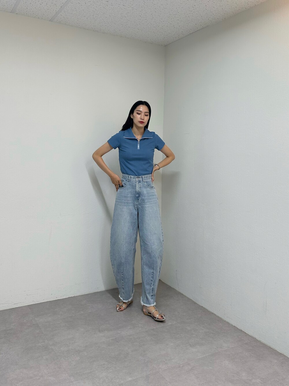 ブルー系のデニムパンツ、シルバー系のサンダル、ブルー系のTシャツ/カットソーを着用したレディースの夏コーディネートの2枚目の写真