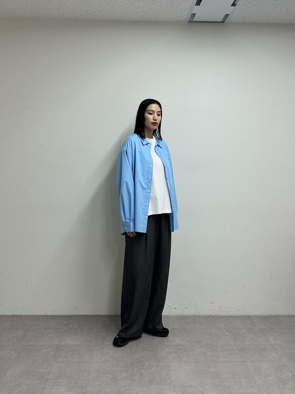 ホワイト系のTシャツ/カットソー、ブルー系のシャツ/ブラウス、グレー系のスラックスを着用したレディースの春コーディネートの4枚目の写真