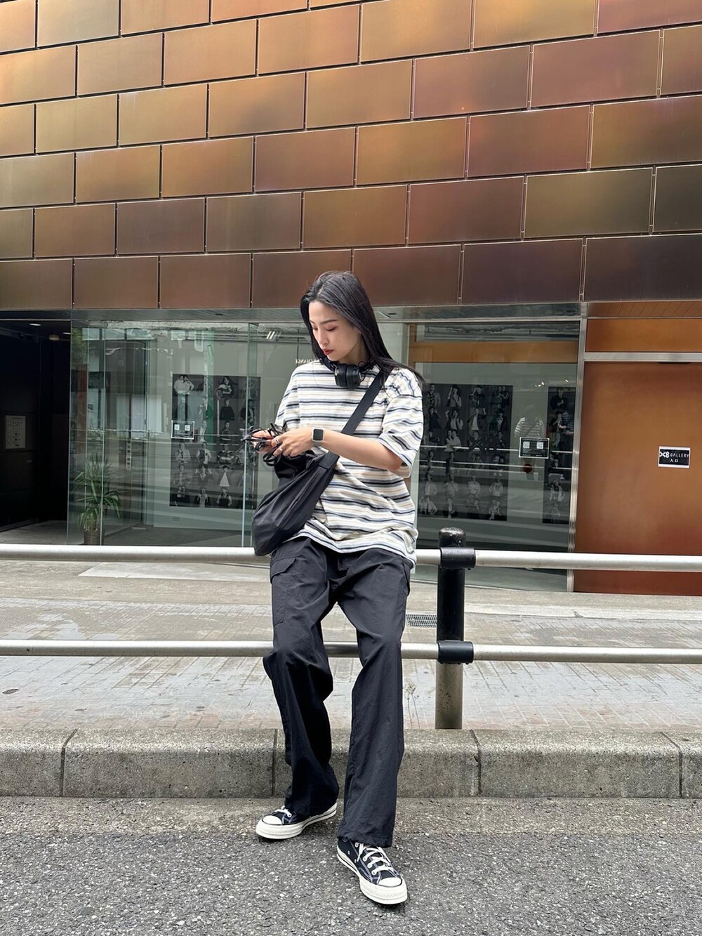 ブラック系のカーゴパンツ、ホワイト系のTシャツ/カットソーを着用したレディースの春コーディネートの2枚目の写真