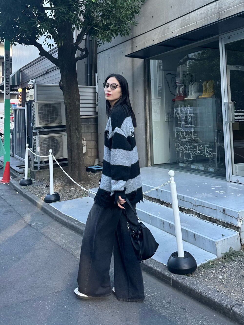 ブラック系のニット/セーター、ブラック系のデニムパンツを着用したレディースの秋コーディネートの2枚目の写真