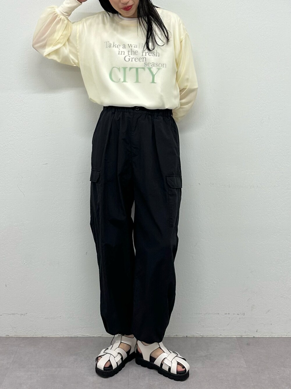 ホワイト系のサンダル、ブラック系のカーゴパンツ、ホワイト系のTシャツ/カットソーを着用したレディースの春コーディネートの2枚目の写真