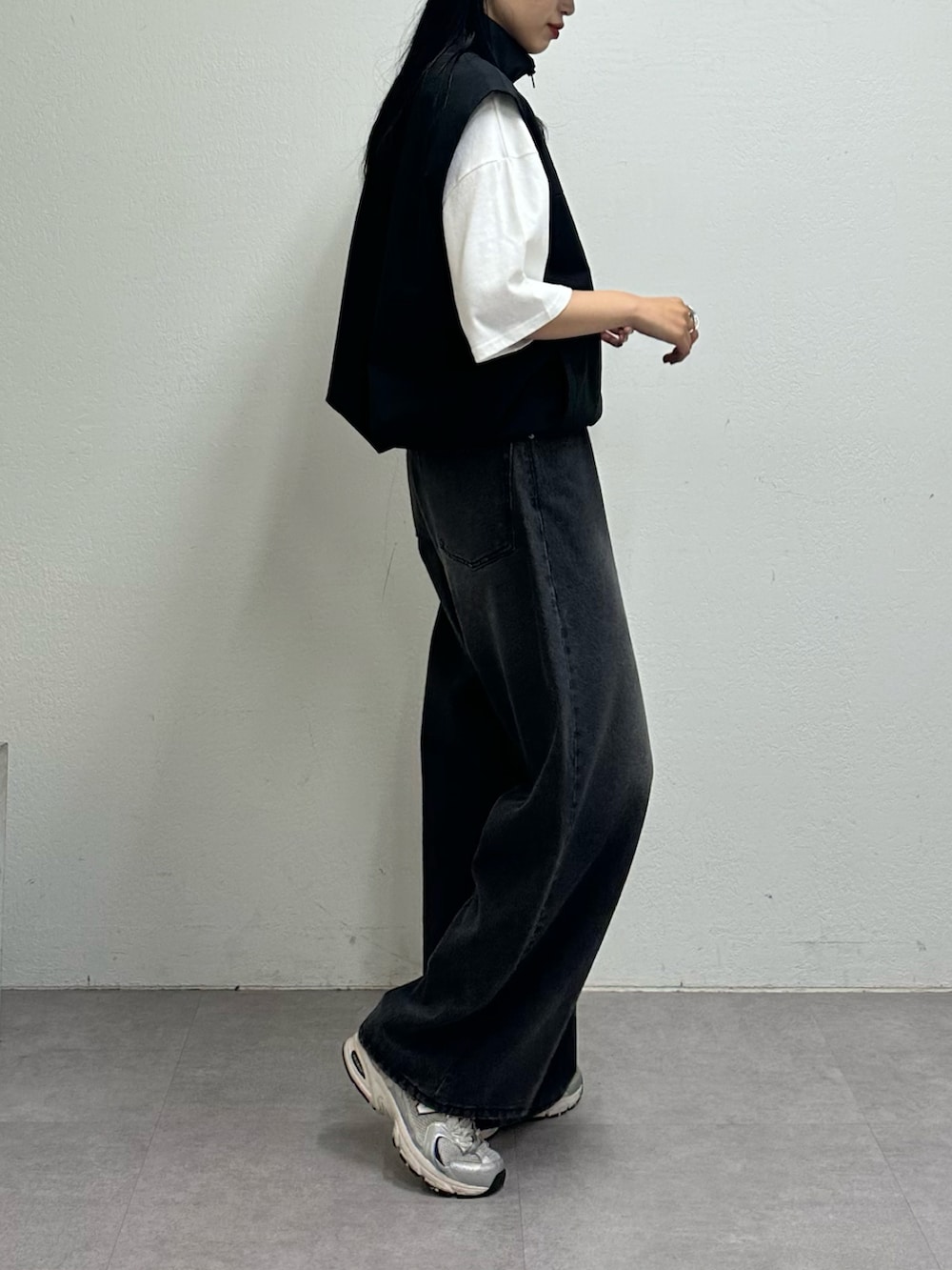 ブラック系のベスト、ホワイト系のTシャツ/カットソー、ブラック系のデニムパンツを着用したレディースの夏コーディネートの3枚目の写真