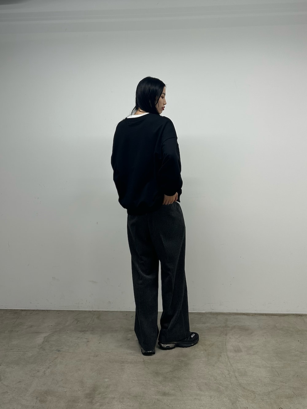 グレー系のスラックス、ブラック系のスウェットを着用したレディースの秋コーディネートの3枚目の写真