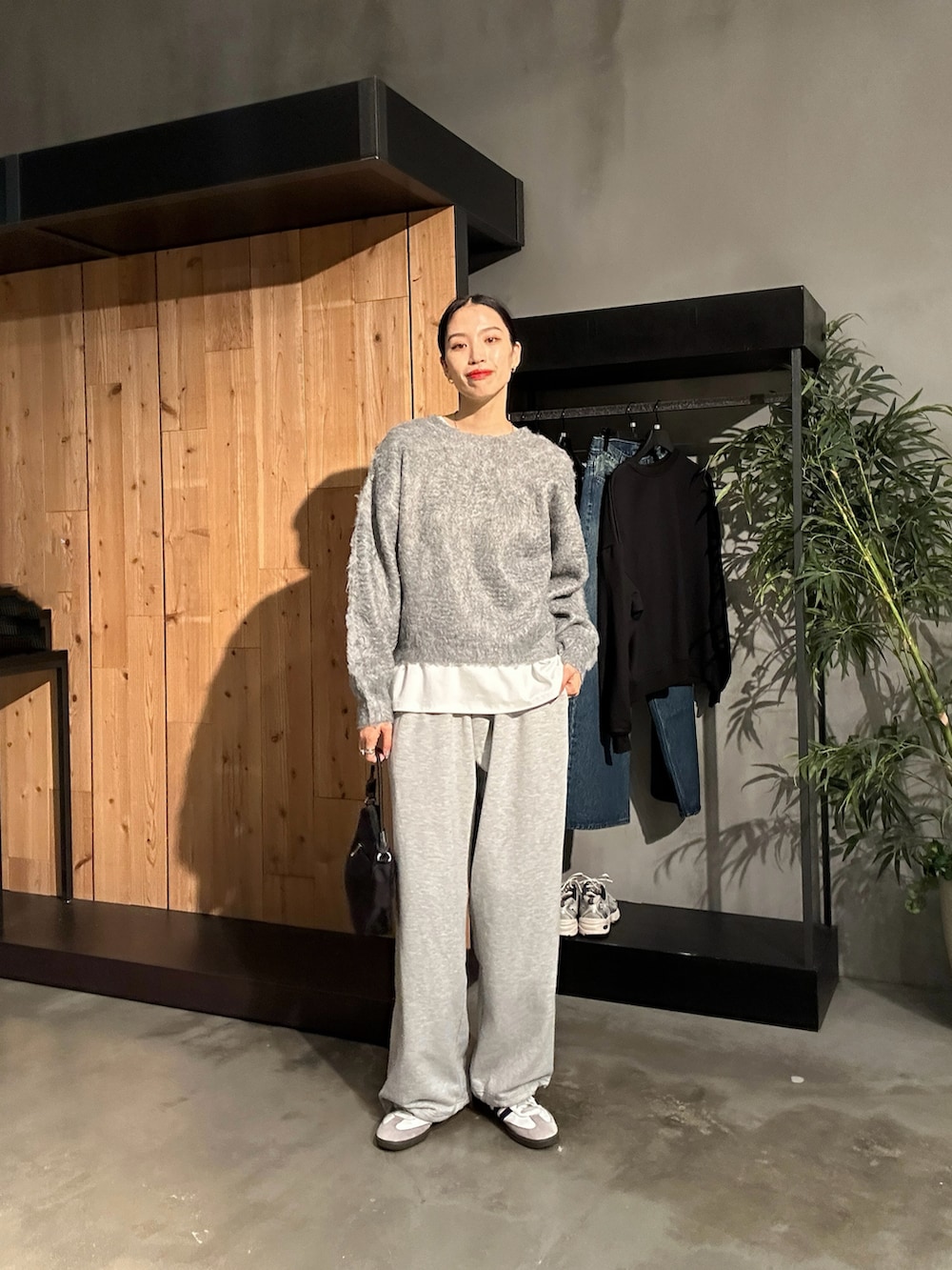 グレー系のスウェットパンツ、グレー系のニット/セーター、ブラック系のハンドバッグを着用したレディースの秋コーディネートの4枚目の写真