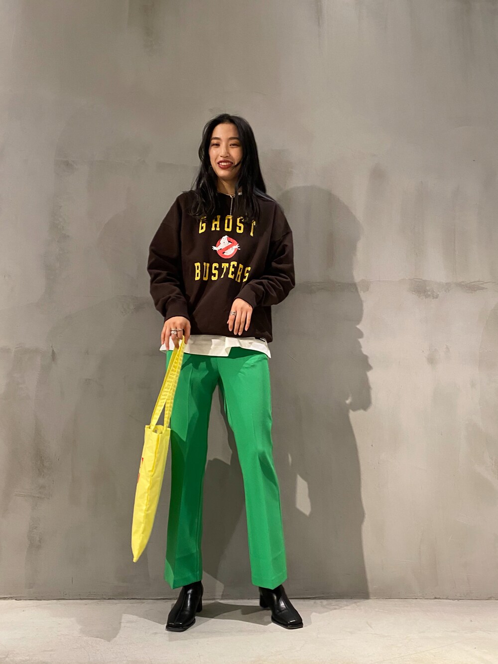 ブラック系のブーツ、グリーン系のその他パンツ、イエロー系のトートバッグを着用したレディースの冬コーディネートの2枚目の写真