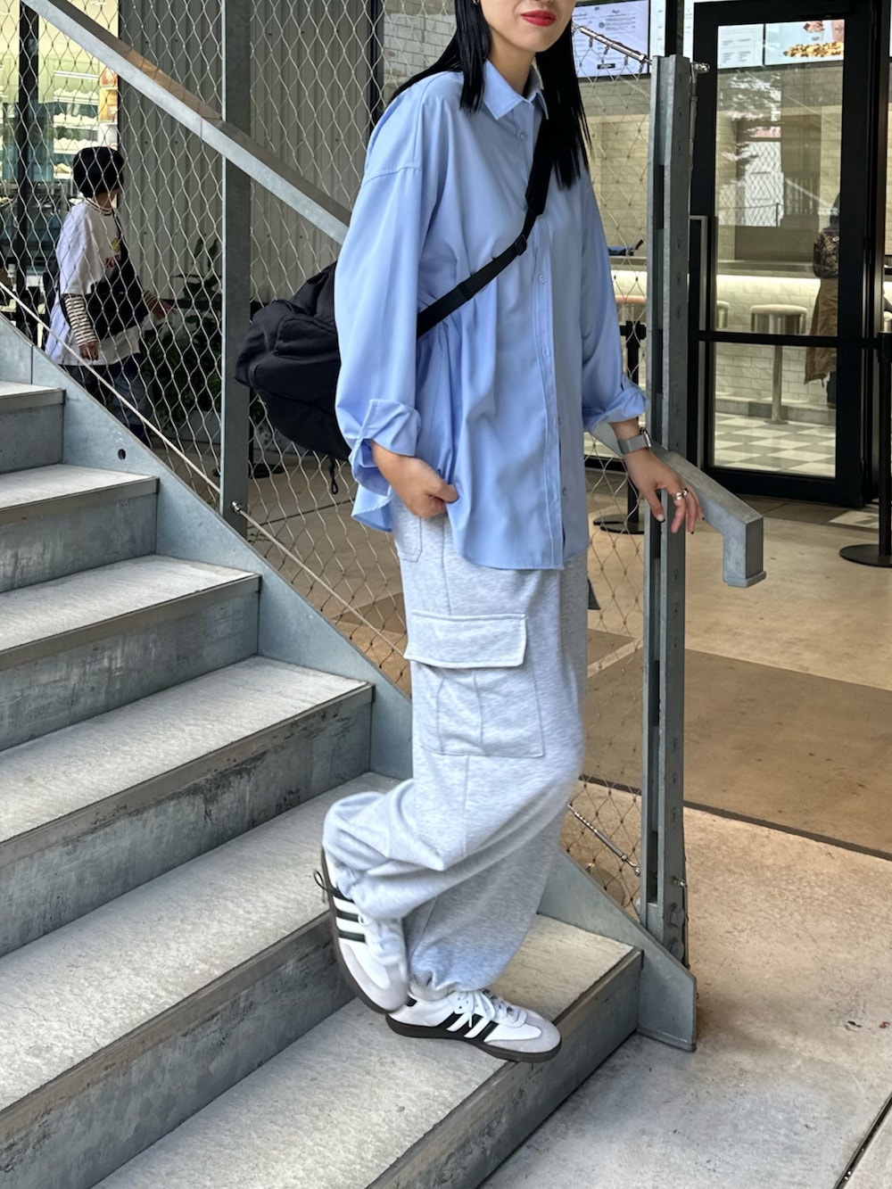 グレー系のカーゴパンツ、ブルー系のシャツ/ブラウス、ブラック系のショルダーバッグを着用したレディースの秋コーディネートの3枚目の写真