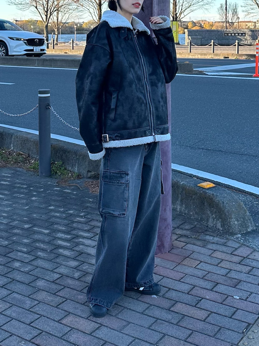 ブラック系のデニムパンツ、ブラック系のムートンコートを着用したレディースの冬コーディネートの3枚目の写真