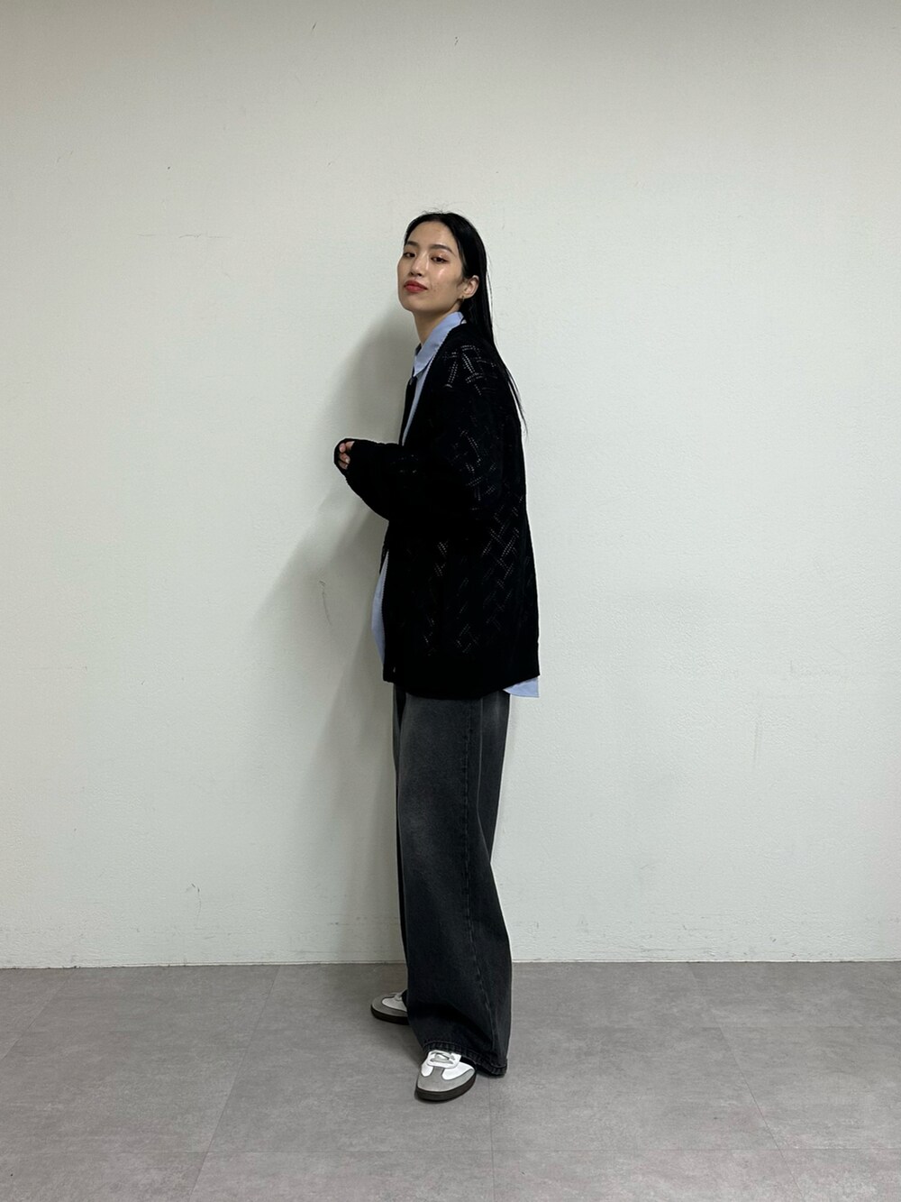 ブラック系のデニムパンツ、ブラック系のカーディガン/ボレロ、ブルー系のシャツ/ブラウスを着用したレディースの春コーディネートの2枚目の写真