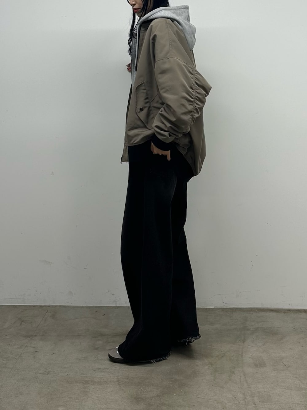 ブラック系のニット/セーター、グレー系のパーカー、ベージュ系のジャケット/アウターを着用したレディースの秋コーディネートの4枚目の写真