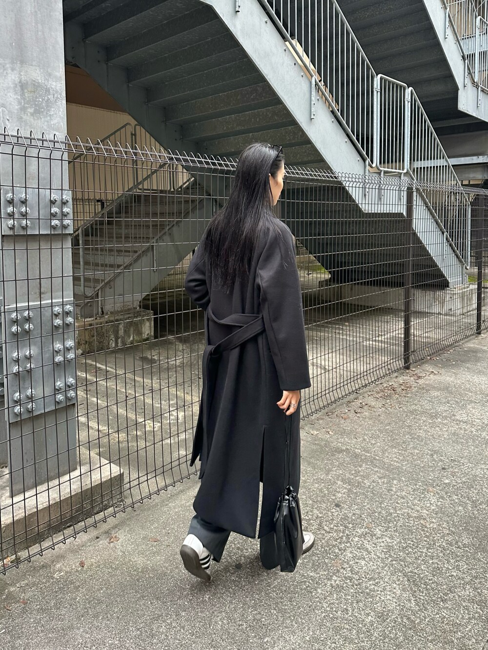 ブラック系のその他アウター、グレー系のスラックス、グレー系のニット/セーターを着用したレディースの秋コーディネートの2枚目の写真