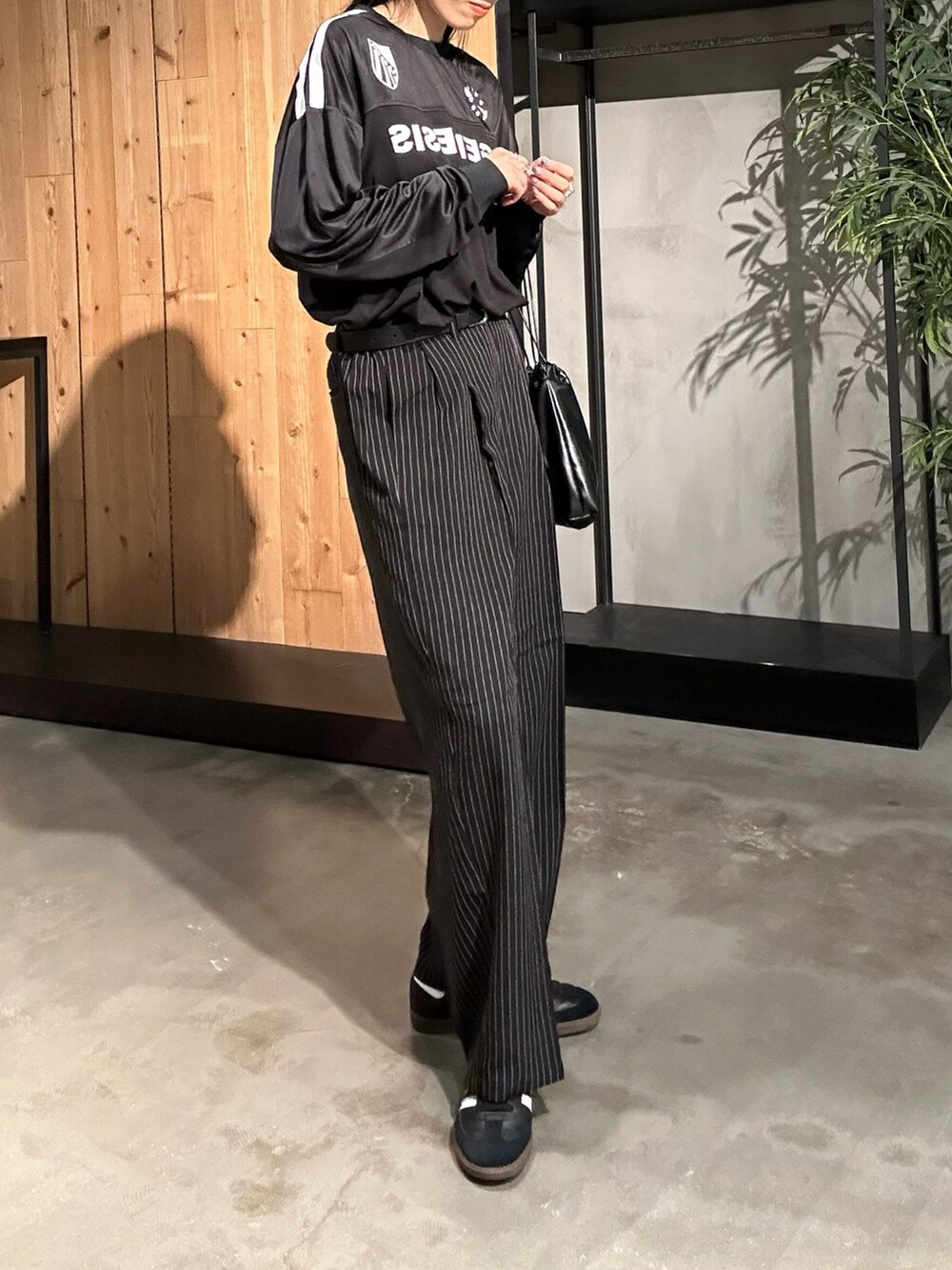 ブラック系のスラックス、ブラック系のTシャツ/カットソーを着用したレディースの秋コーディネートの4枚目の写真