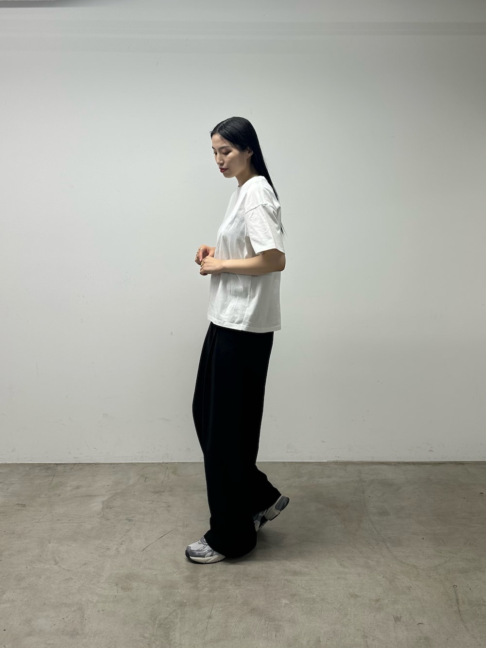 ホワイト系のTシャツ/カットソー、ブラック系のスラックスを着用したレディースの春コーディネートの2枚目の写真