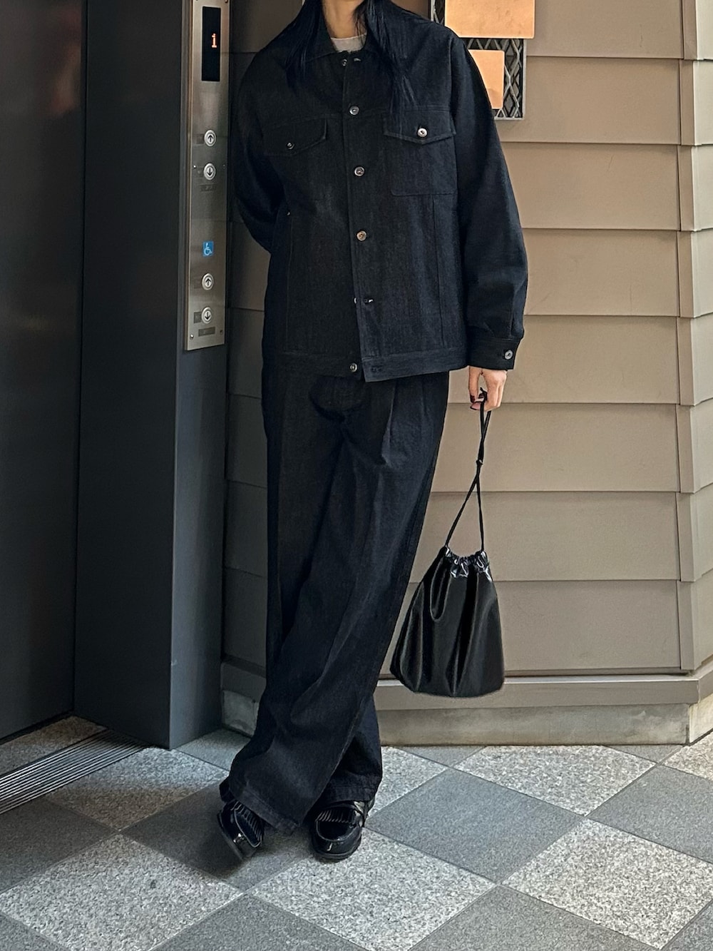 ブラック系のデニムジャケット、ブラック系のデニムパンツを着用したレディースの春コーディネートの2枚目の写真