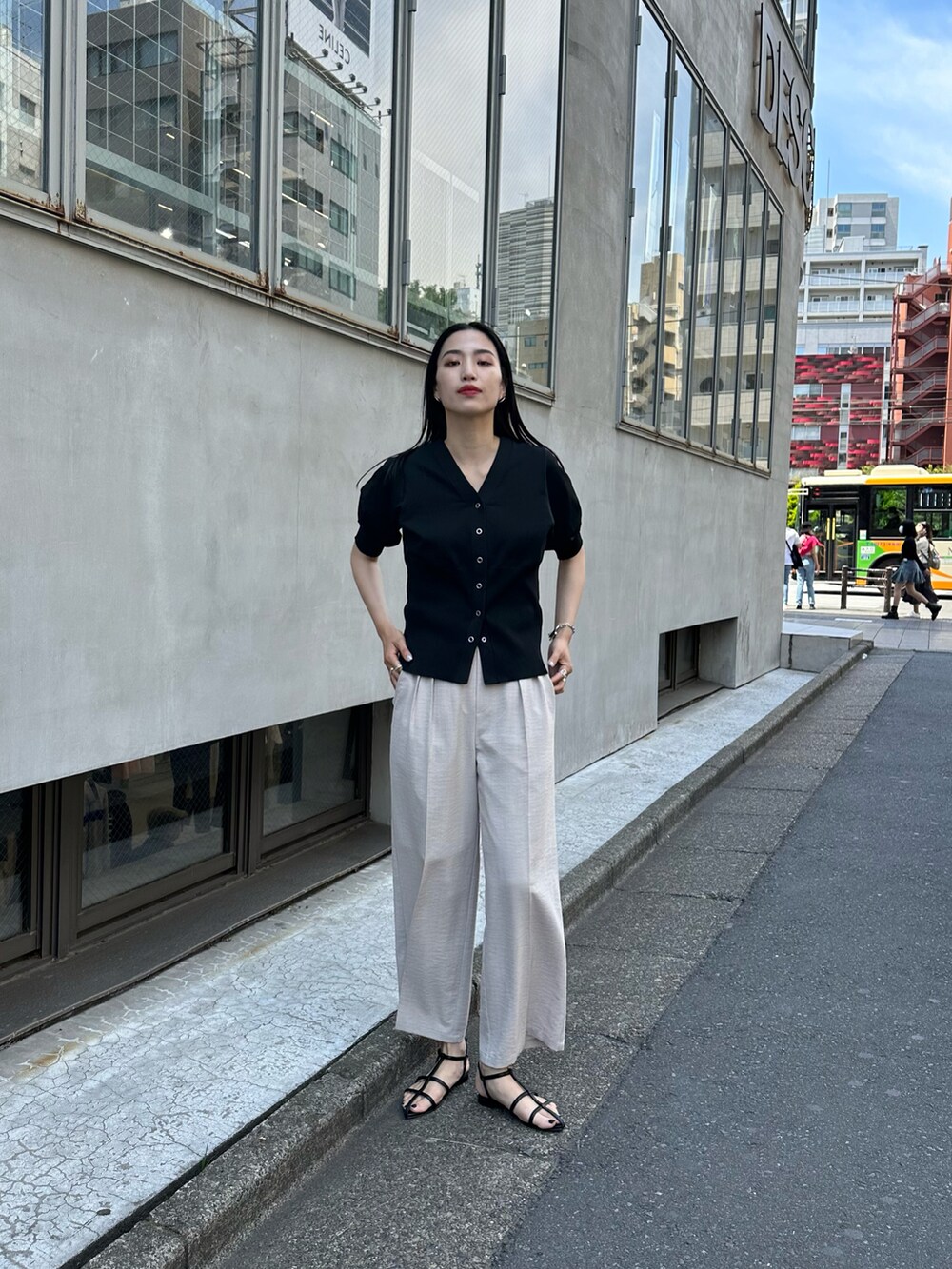 ブラック系のサンダル、ベージュ系のスラックス、ブラック系のカーディガン/ボレロを着用したレディースの春コーディネートの2枚目の写真