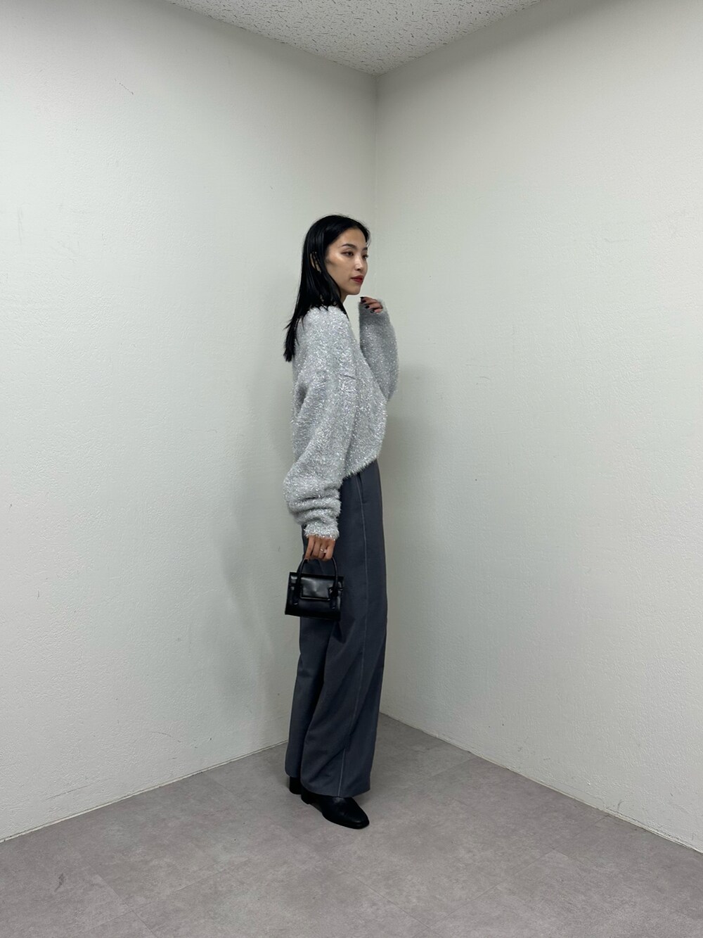 ブラック系のショルダーバッグ、シルバー系のニット/セーターを着用したレディースの秋コーディネートの2枚目の写真