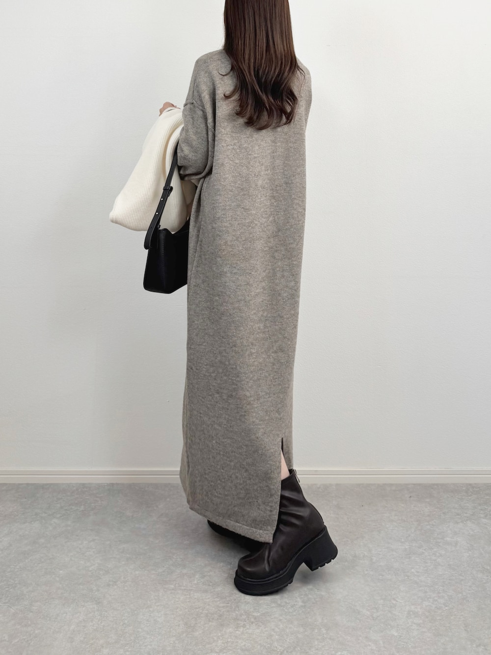 ベージュ系のワンピースを着用したレディースの冬コーディネートの2枚目の写真