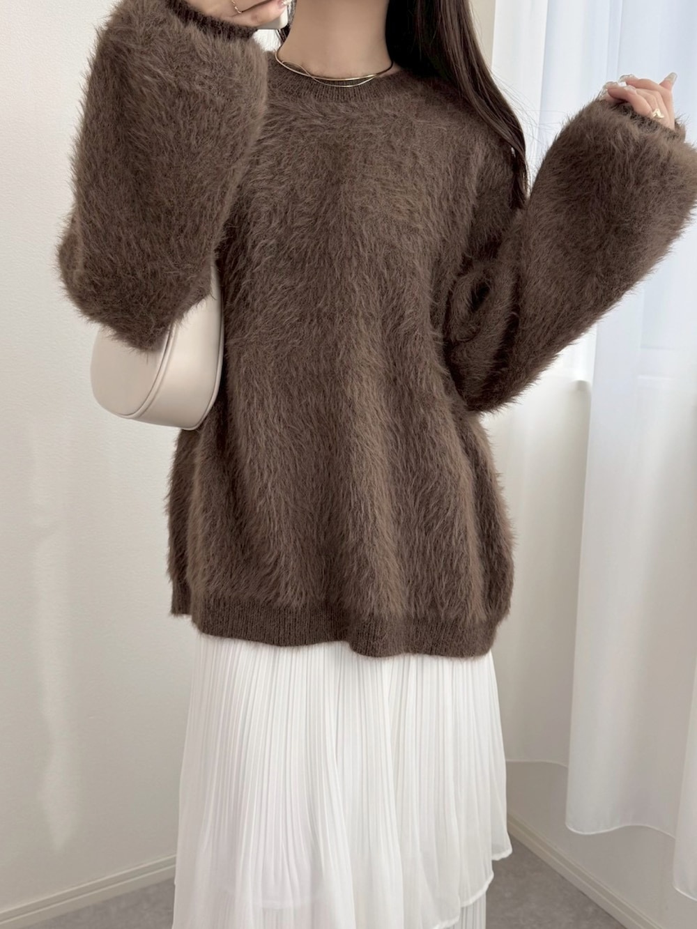 ホワイト系のスカート、ブラウン系のニット/セーターを着用したレディースの冬コーディネートの2枚目の写真