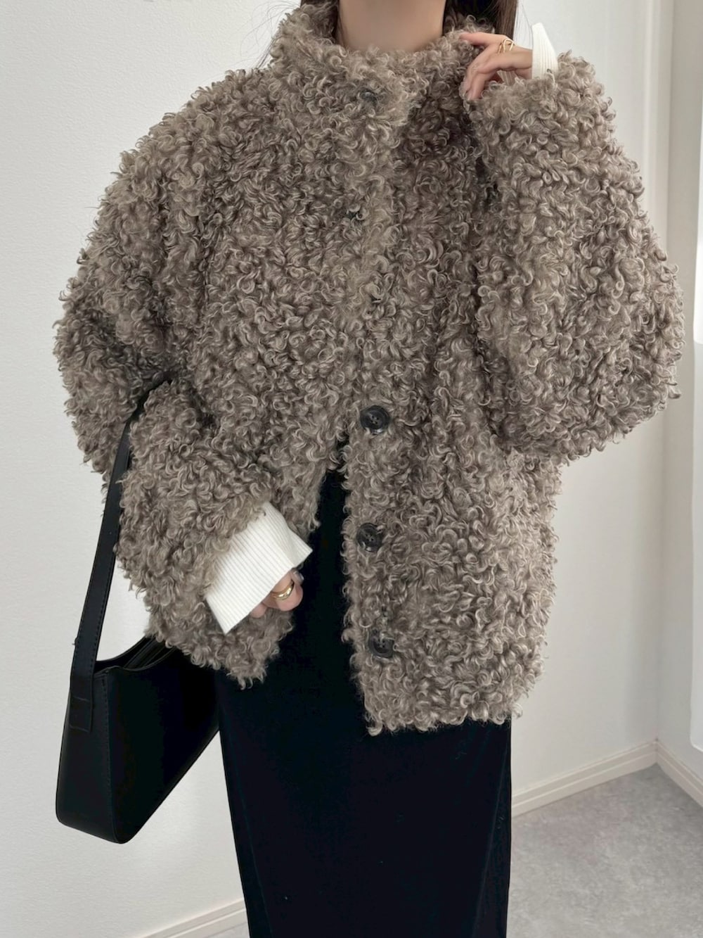 ベージュ系のブルゾン、ブラック系のワンピースを着用したレディースの冬コーディネートの2枚目の写真