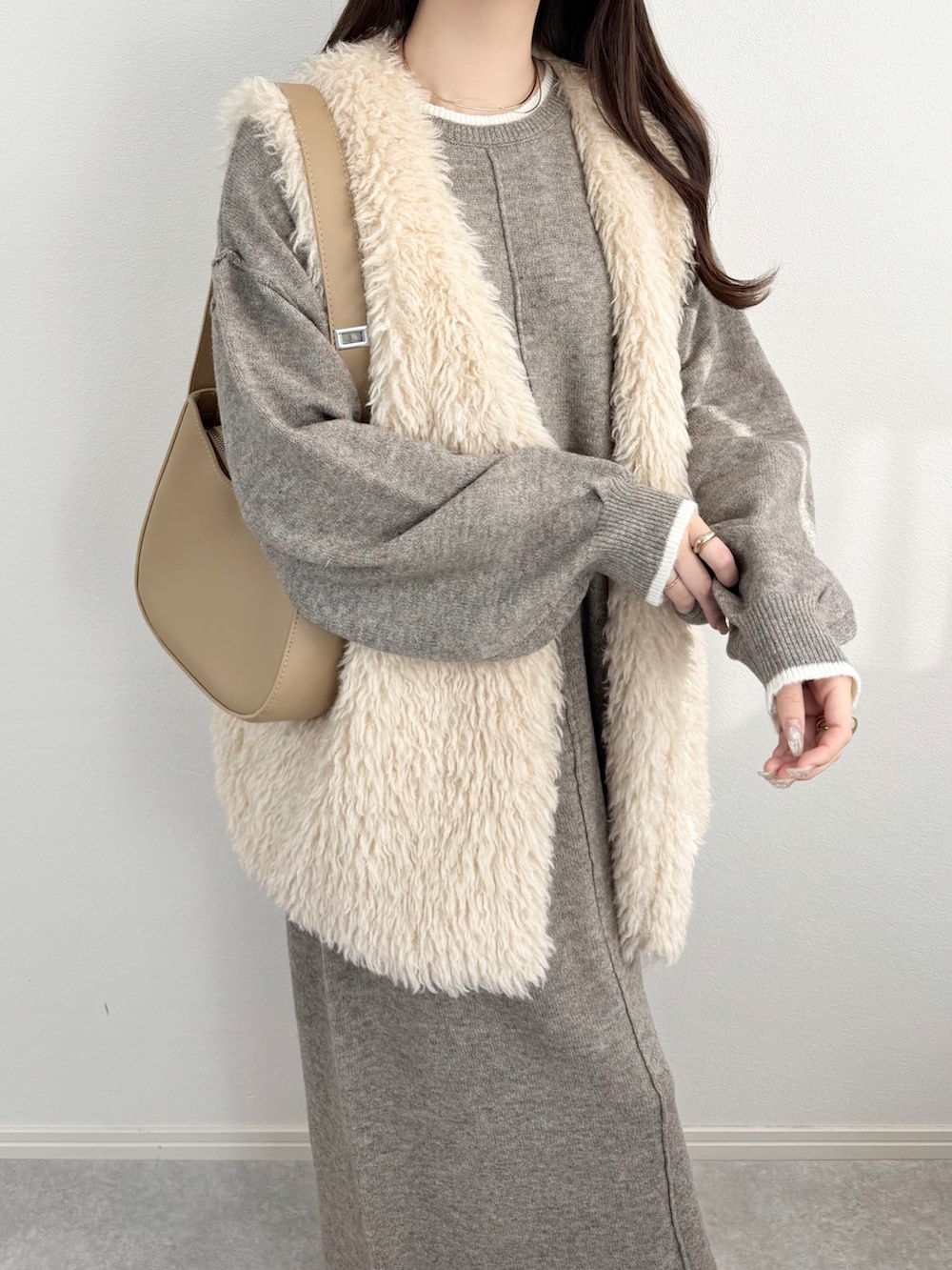 ベージュ系のワンピースを着用したレディースの冬コーディネートの3枚目の写真