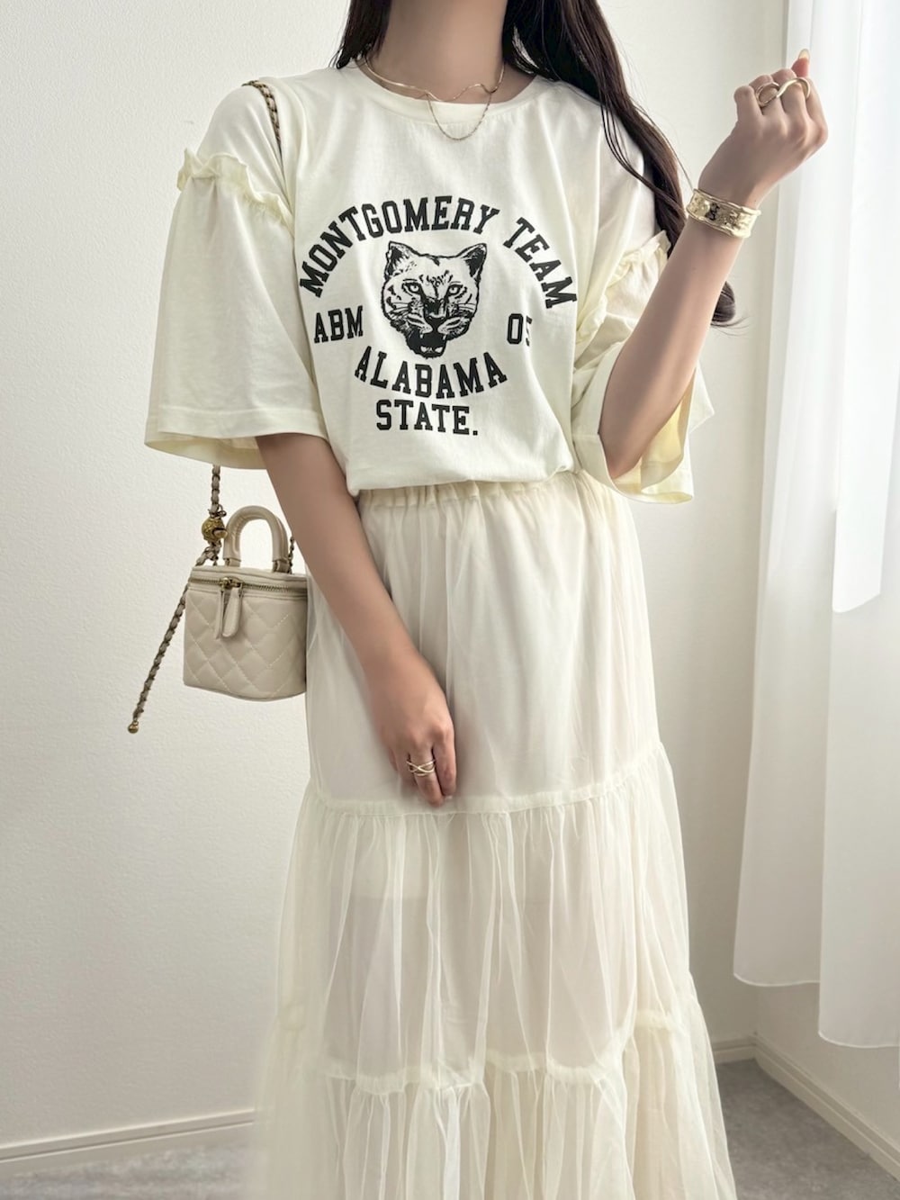 ホワイト系のスカート、ブラウン系のスニーカー、ホワイト系のショルダーバッグを着用したレディースの夏コーディネートの3枚目の写真