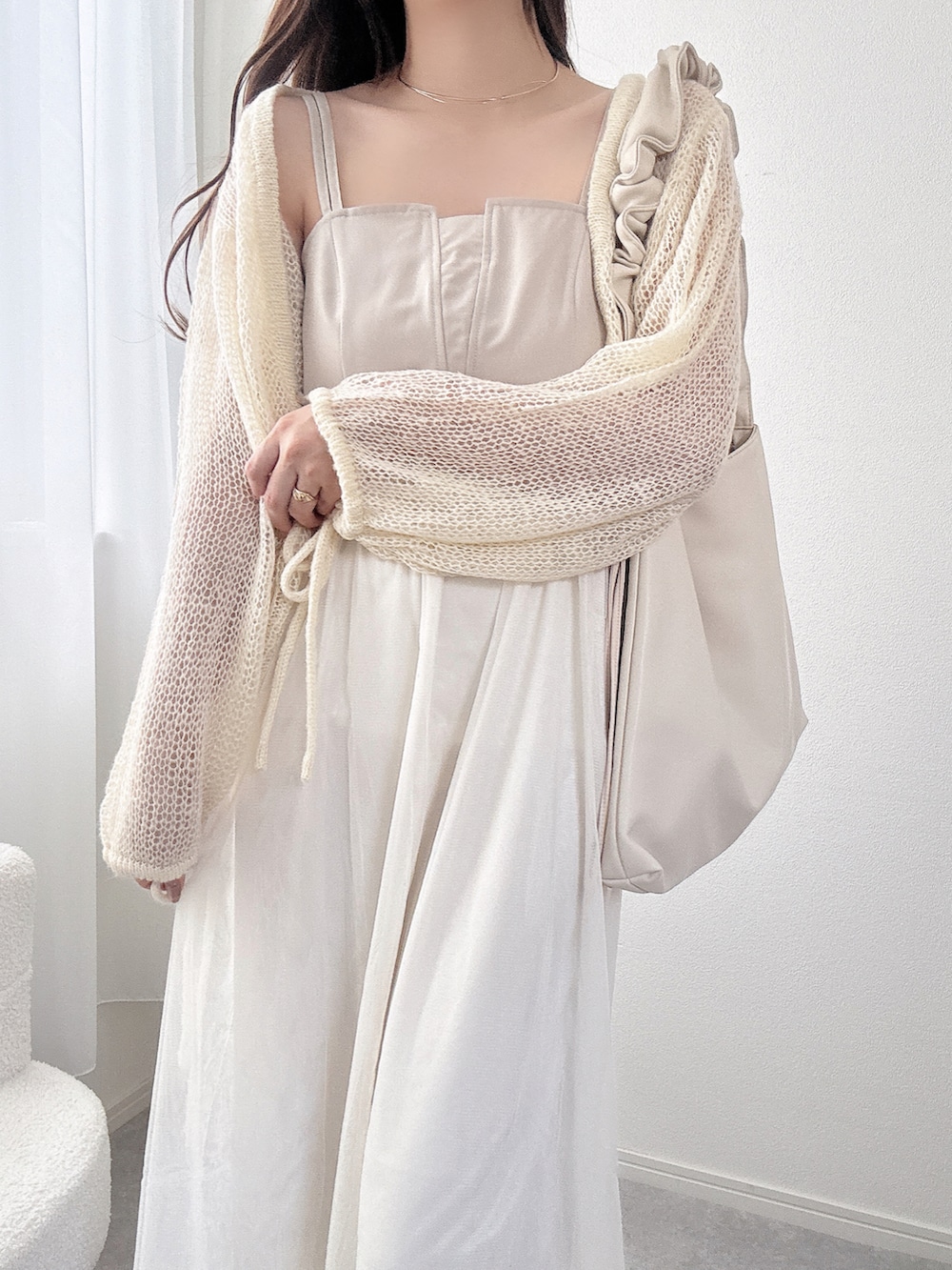 ホワイト系のカーディガン/ボレロ、ホワイト系のワンピースを着用したレディースの春コーディネートの2枚目の写真