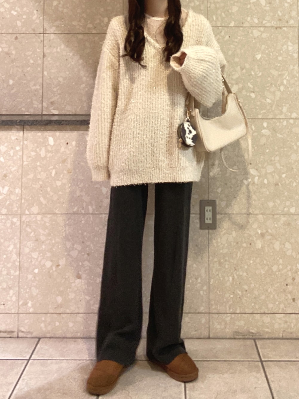 ホワイト系のニット/セーター、ホワイト系のTシャツ/カットソー、ホワイト系のショルダーバッグを着用したレディースの冬コーディネートの2枚目の写真