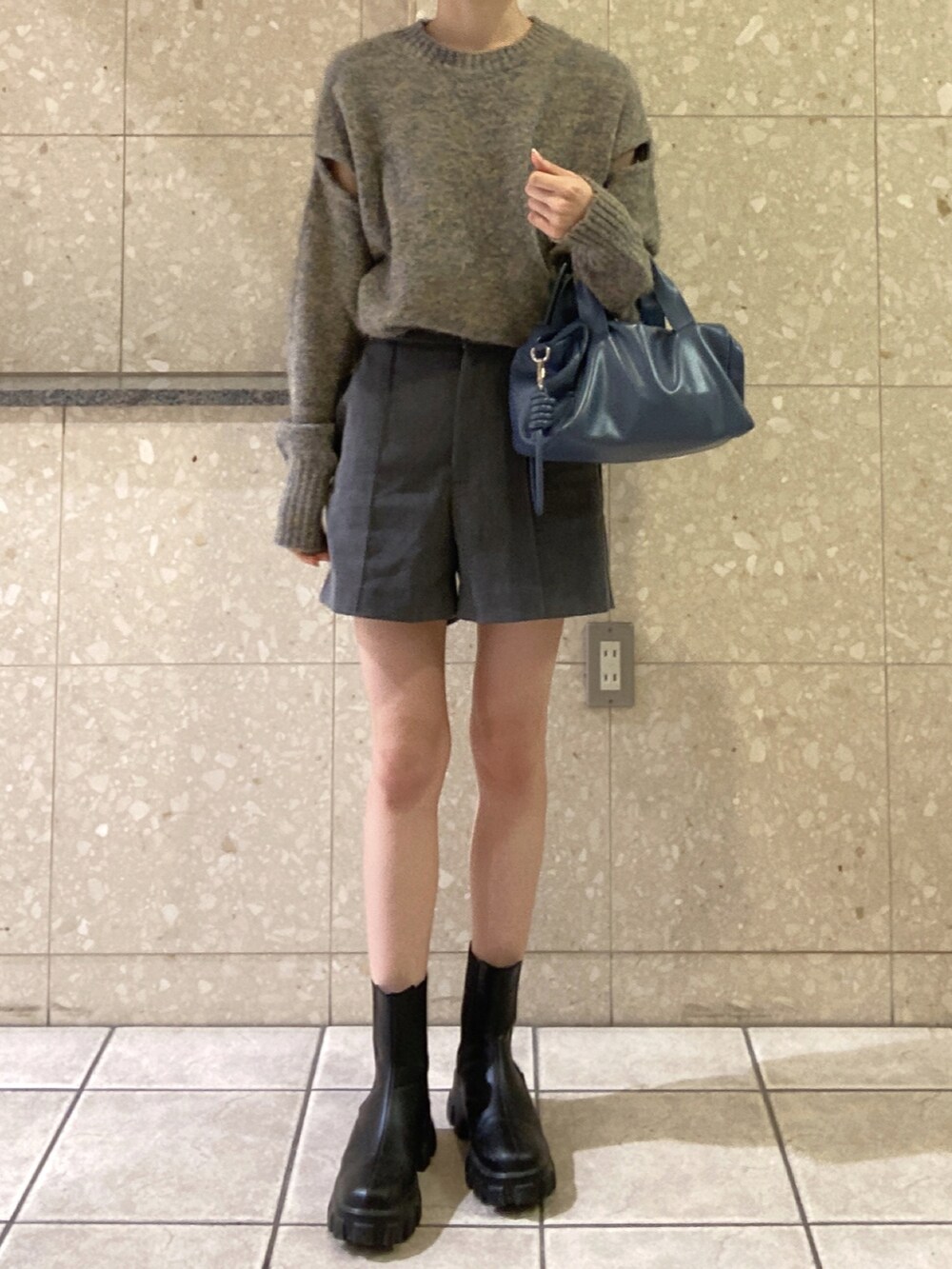 グレー系のニット/セーター、グレー系のその他パンツ、ブルー系のボストンバッグを着用したレディースの春コーディネートの2枚目の写真