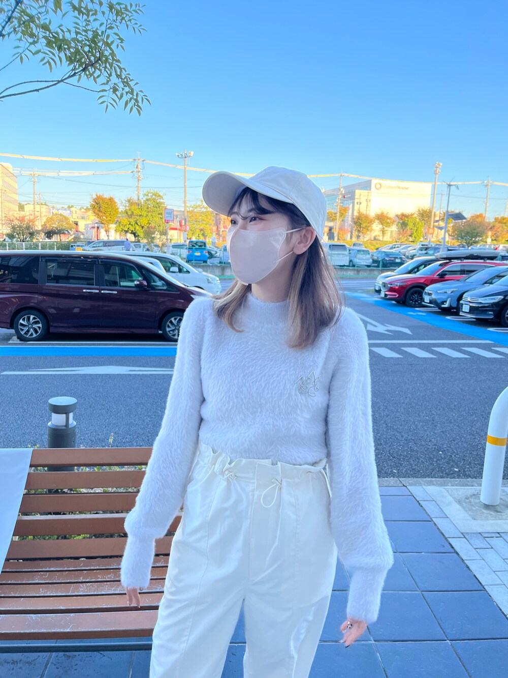 ホワイト系のスラックス、ブルー系のニット/セーター、ホワイト系のブーツを着用したレディースの秋コーディネートの3枚目の写真