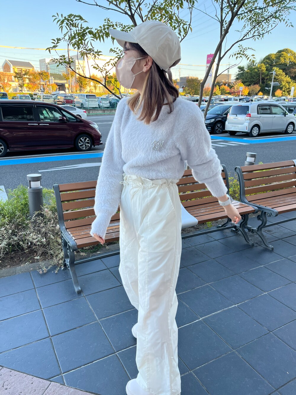 ホワイト系のスラックス、ブルー系のニット/セーター、ホワイト系のブーツを着用したレディースの秋コーディネートの2枚目の写真