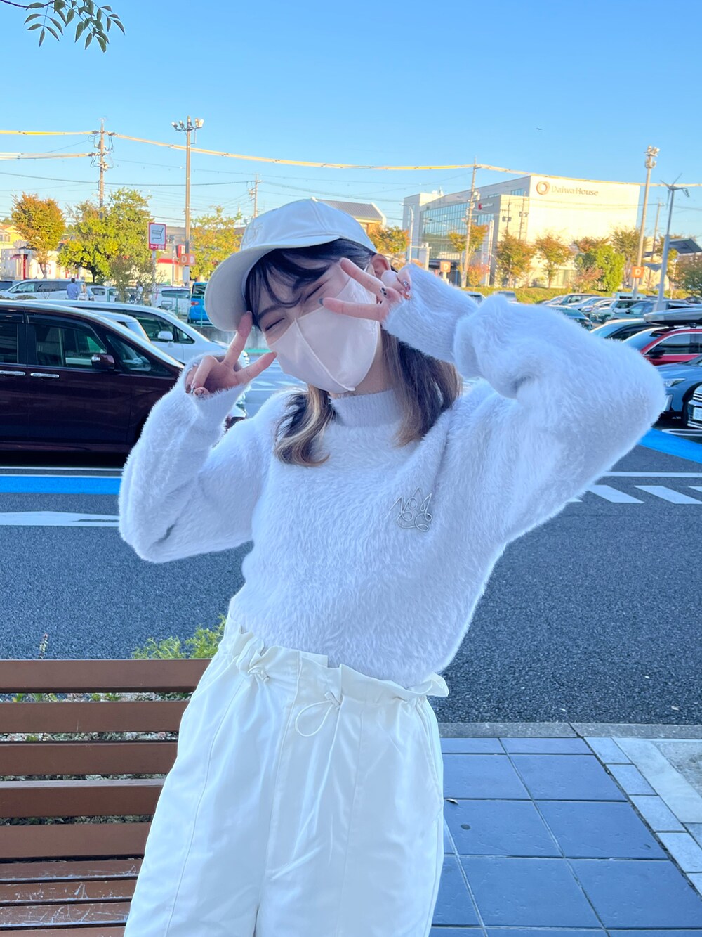 ホワイト系のスラックス、ブルー系のニット/セーター、ホワイト系のブーツを着用したレディースの秋コーディネートの4枚目の写真