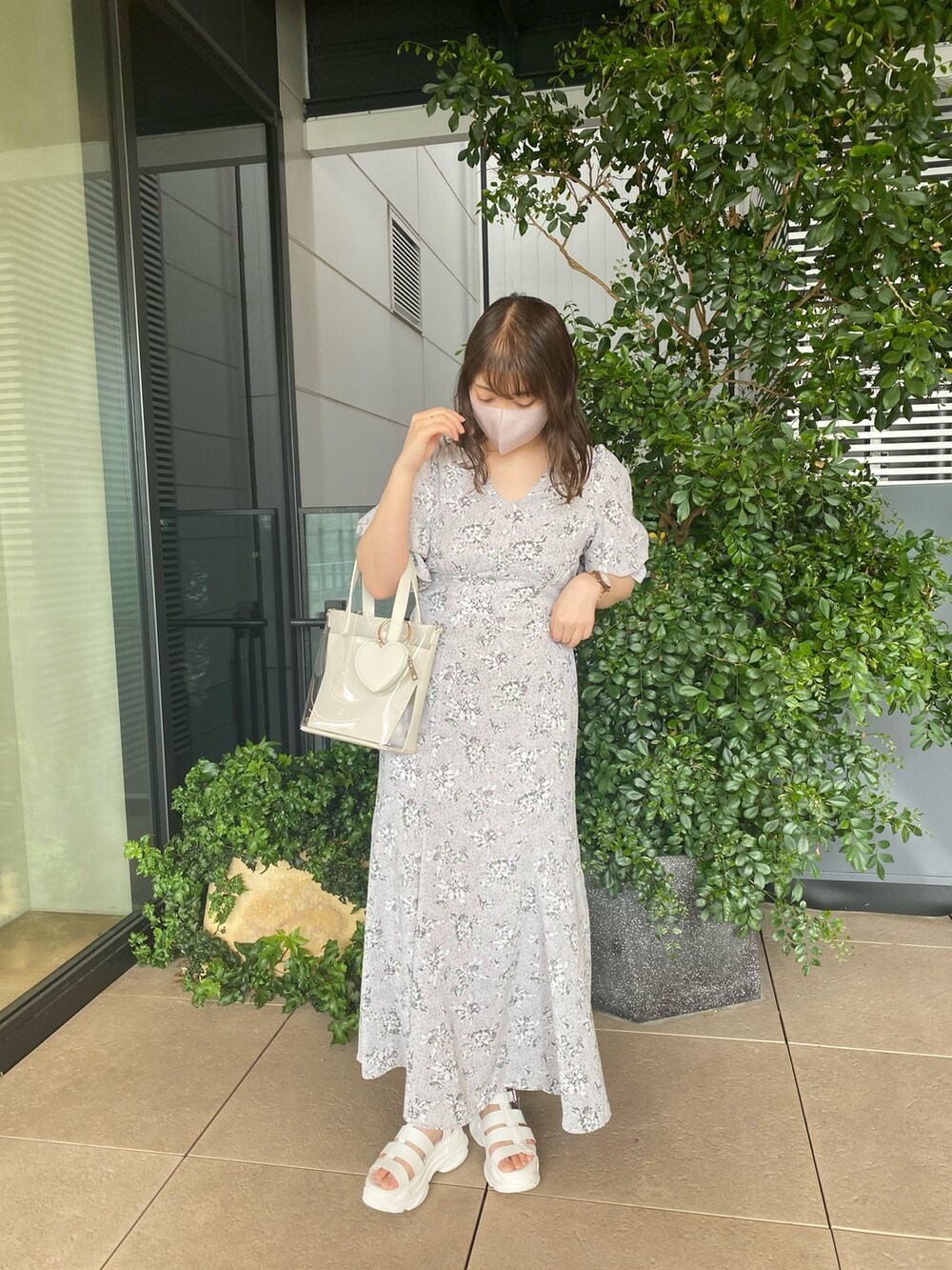 グレー系のワンピース、ホワイト系のサンダル、ホワイト系のショルダーバッグを着用したレディースの春コーディネートの3枚目の写真