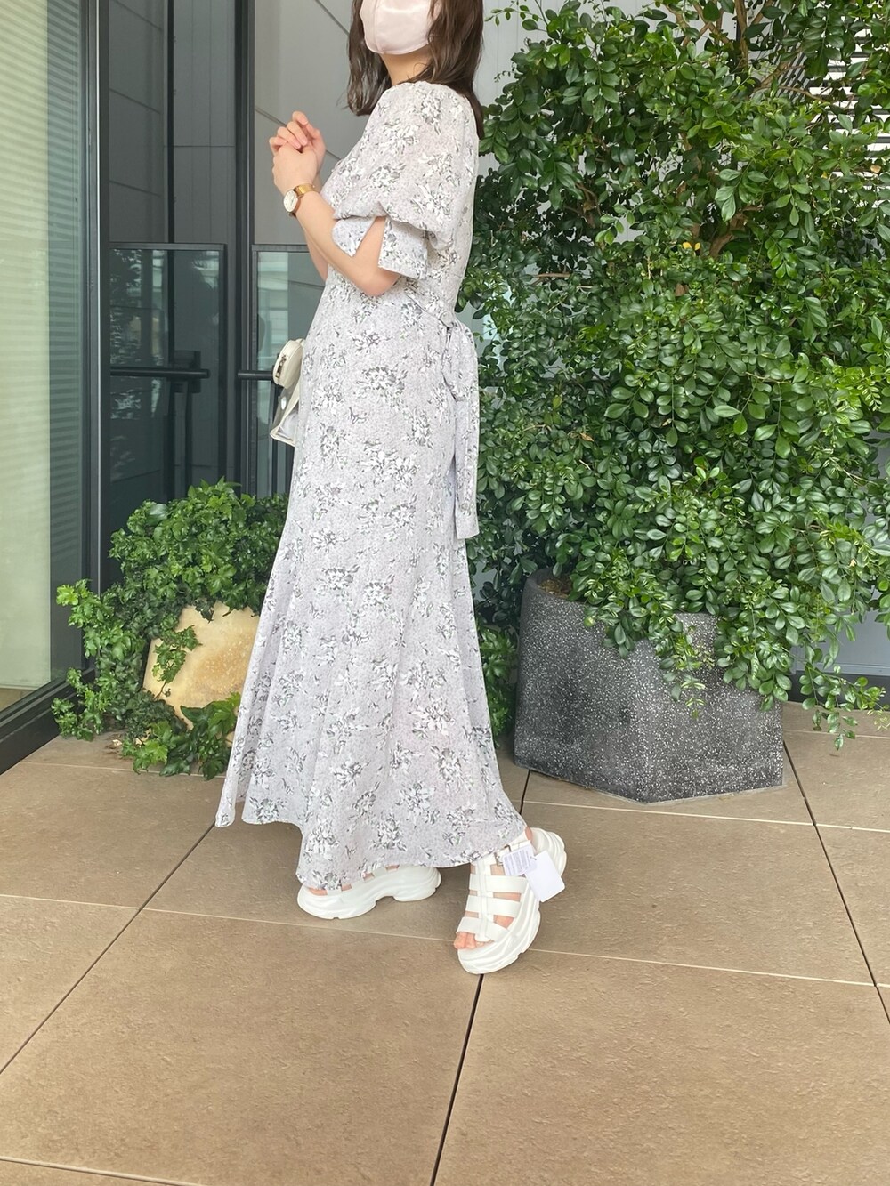 グレー系のワンピース、ホワイト系のサンダル、ホワイト系のショルダーバッグを着用したレディースの春コーディネートの2枚目の写真