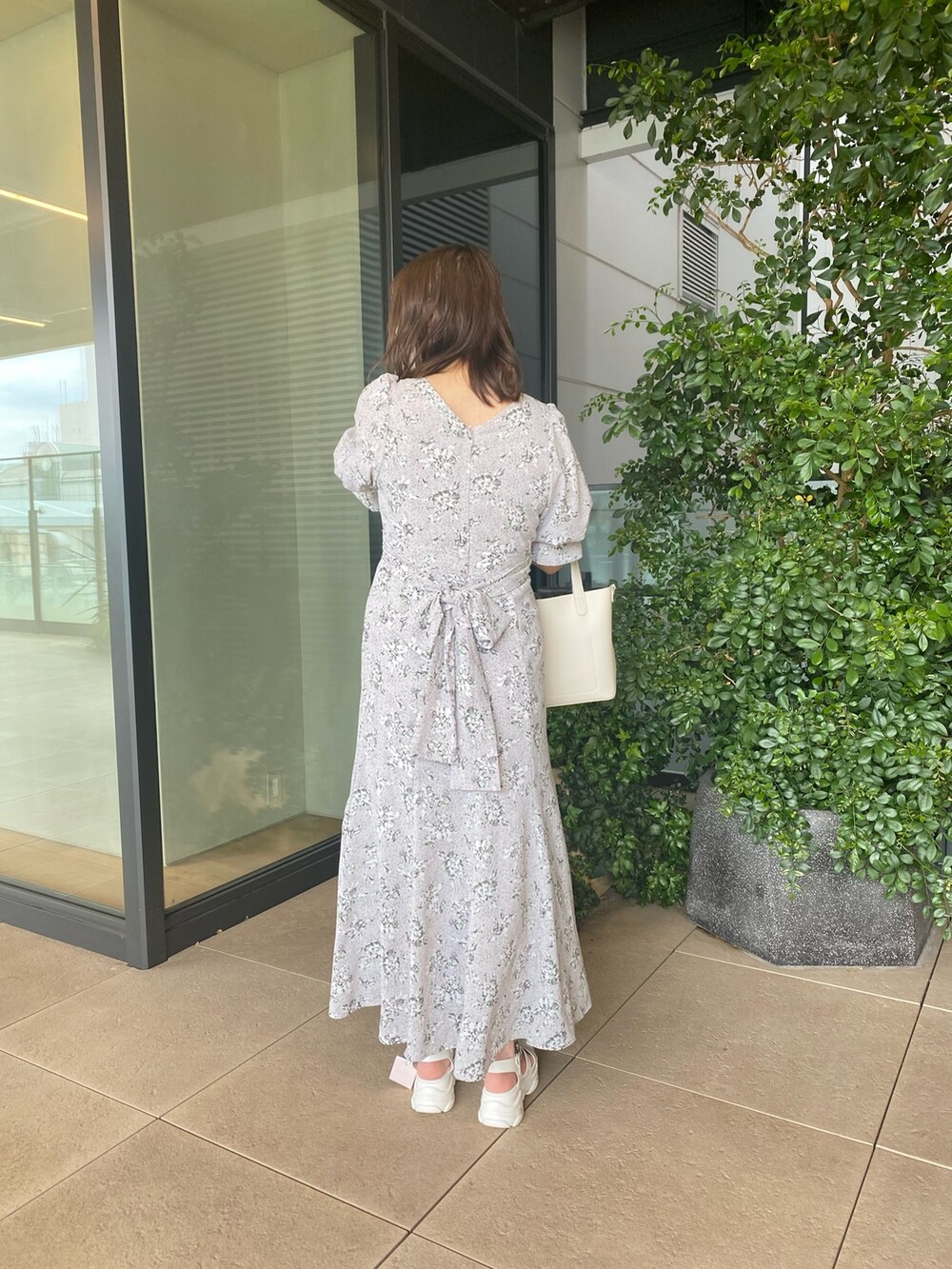 グレー系のワンピース、ホワイト系のサンダル、ホワイト系のショルダーバッグを着用したレディースの春コーディネートの4枚目の写真
