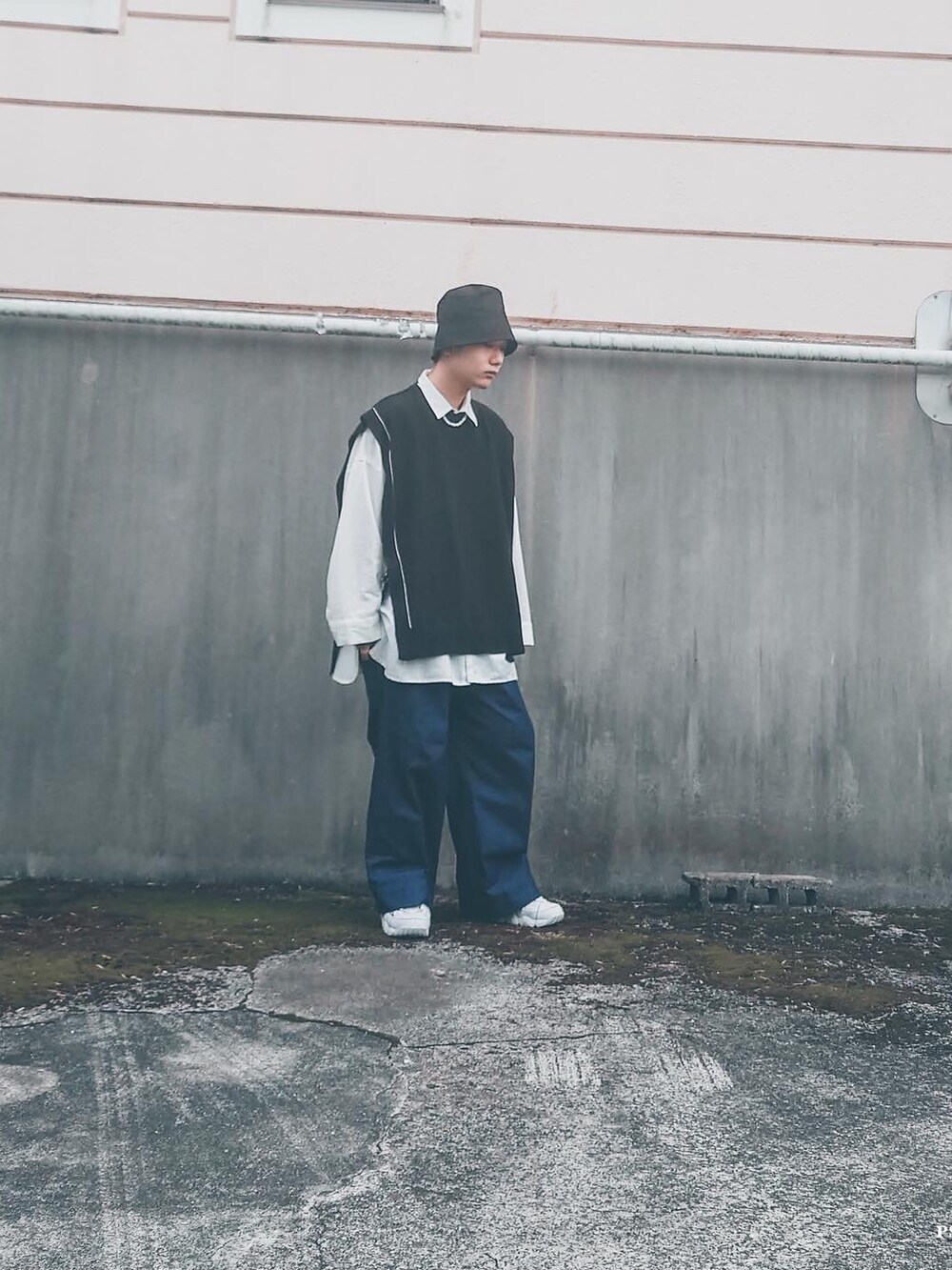 ブラック系のニット/セーター、ブルー系のデニムパンツ、ホワイト系のシャツ/ブラウスを着用したメンズの春コーディネートの2枚目の写真