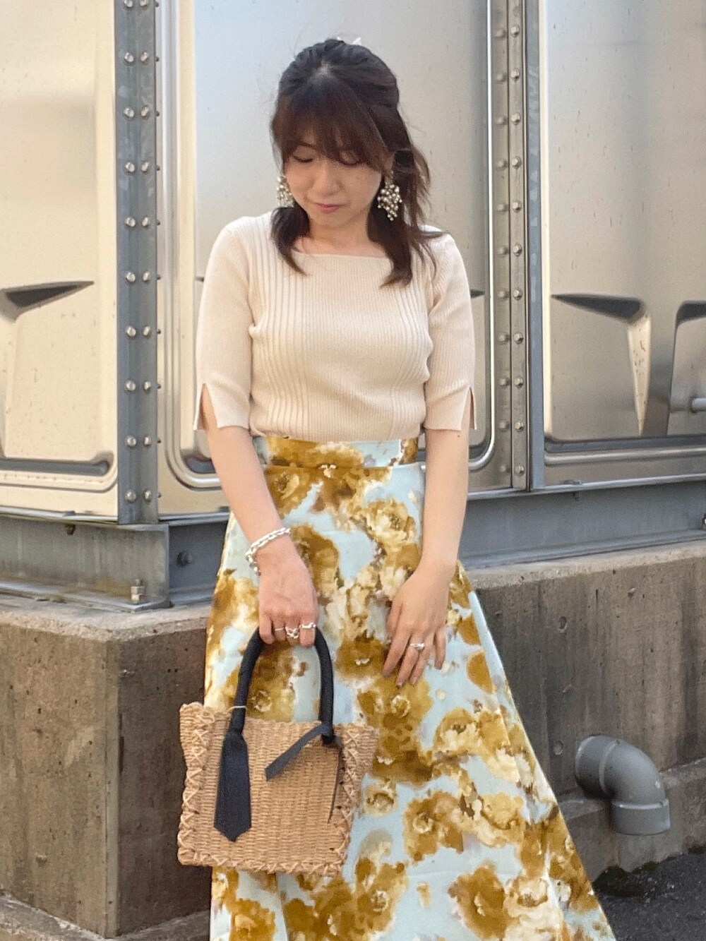 ホワイト系のニット/セーター、ブルー系のスカート、ベージュ系のボストンバッグを着用したレディースの夏コーディネートの4枚目の写真