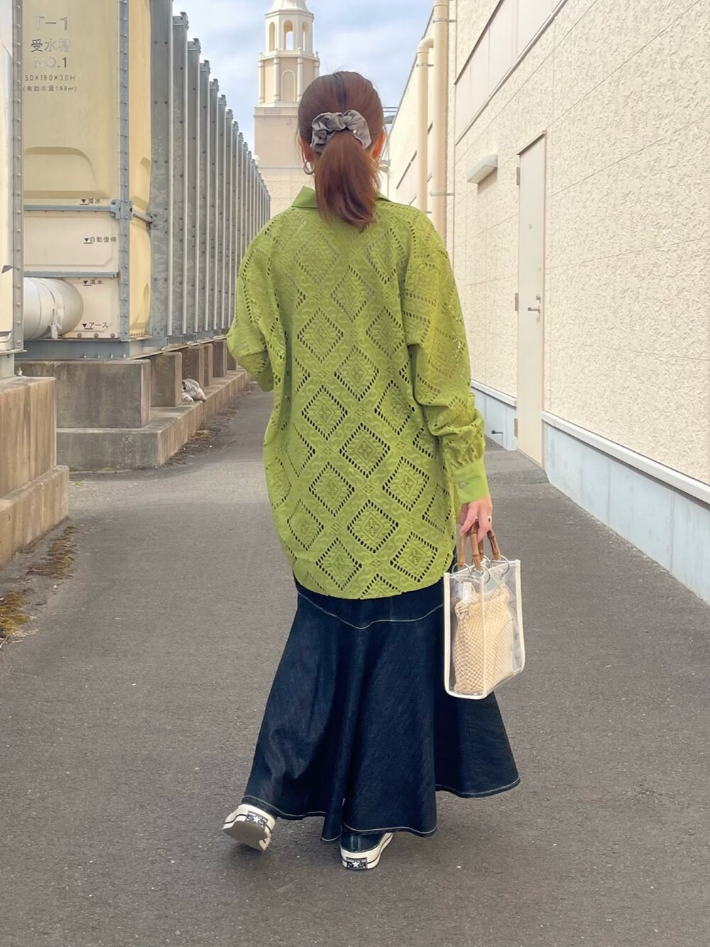 グリーン系のシャツ/ブラウス、ブルー系のスカート、ブラック系のスニーカーを着用したレディースの春コーディネートの3枚目の写真