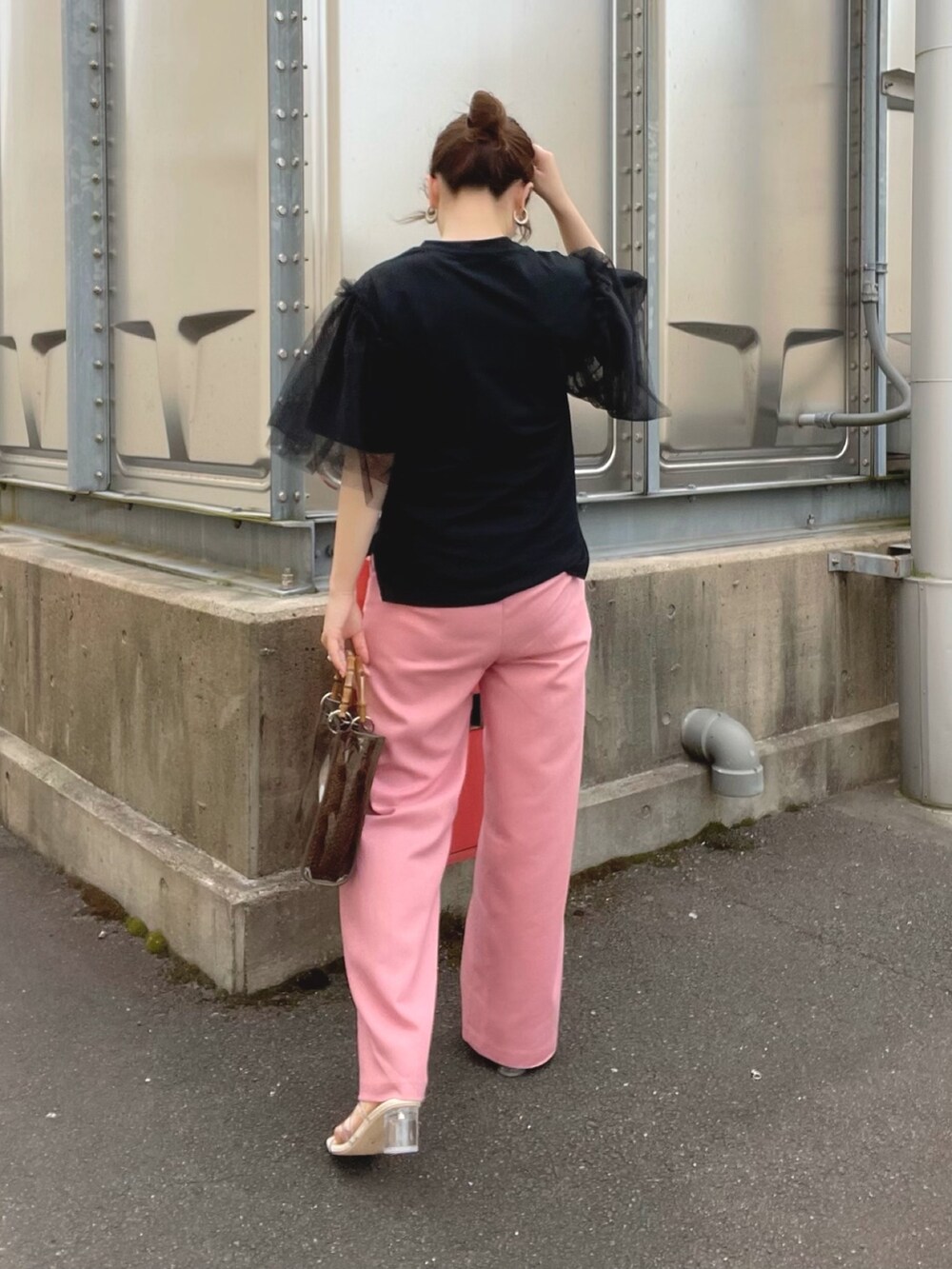 ブラック系のTシャツ/カットソー、ピンク系のパンツ、ホワイト系のサンダルを着用したレディースの夏コーディネートの3枚目の写真