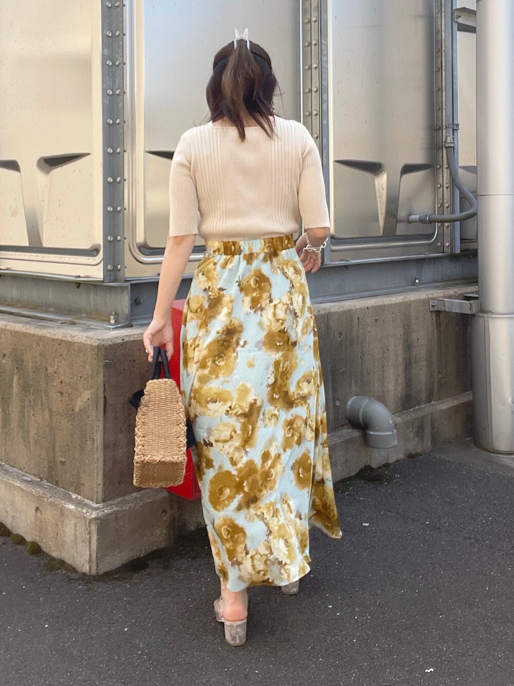 ホワイト系のニット/セーター、ブルー系のスカート、ベージュ系のボストンバッグを着用したレディースの夏コーディネートの3枚目の写真