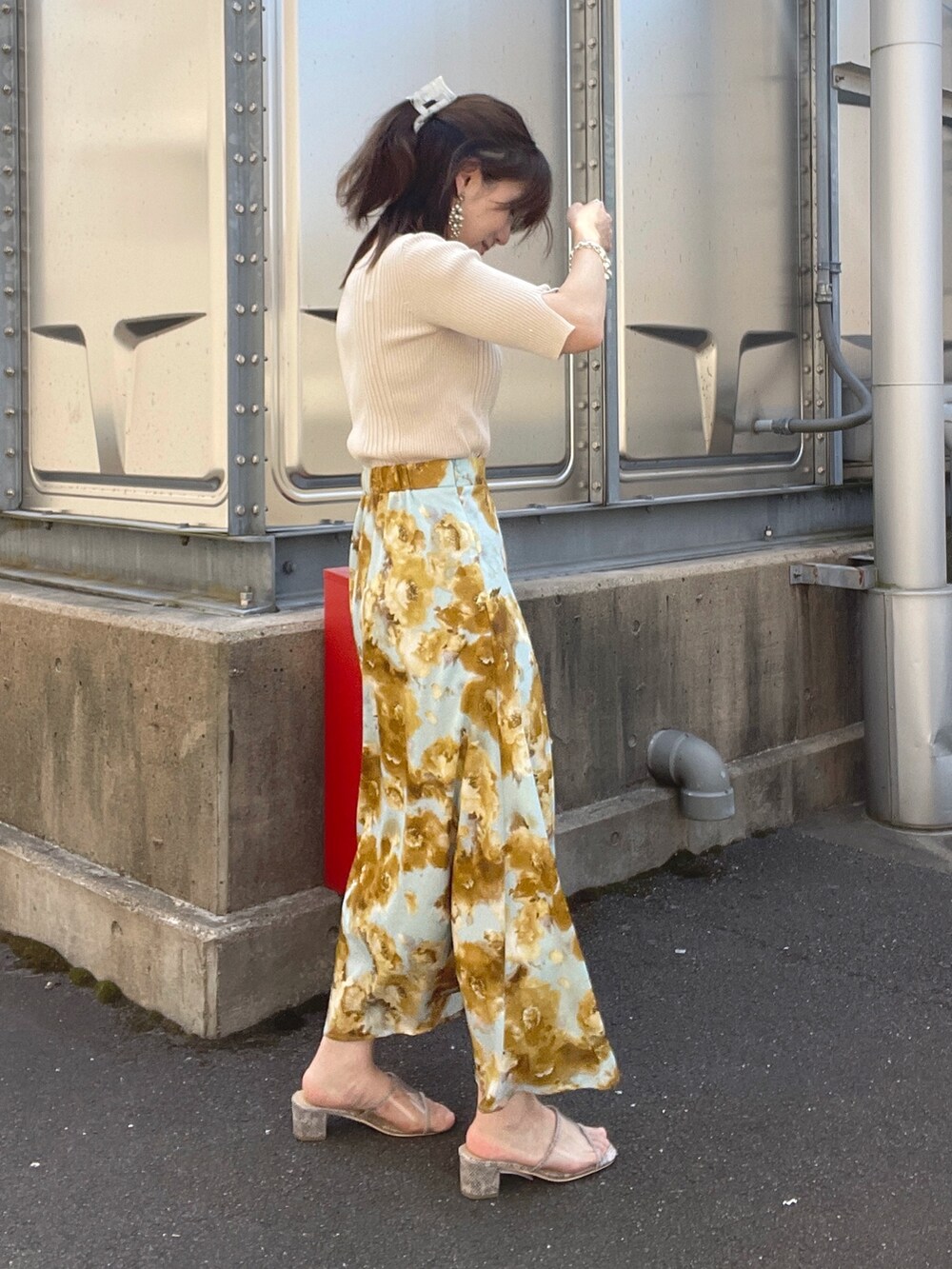 ホワイト系のニット/セーター、ブルー系のスカート、ベージュ系のボストンバッグを着用したレディースの夏コーディネートの2枚目の写真