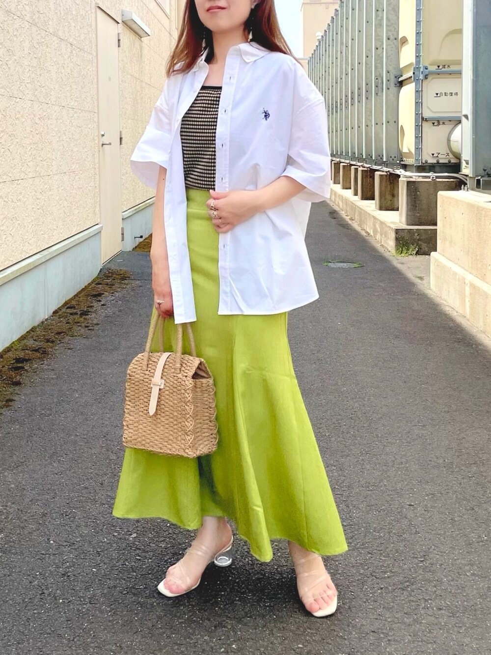 グリーン系のスカート、ベージュ系のトートバッグ、ホワイト系のサンダルを着用したレディースの春コーディネートの4枚目の写真