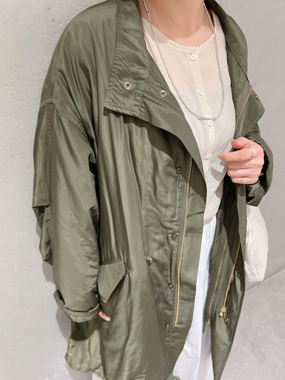 ホワイト系のスカート、ホワイト系のショルダーバッグ、ベージュ系のシャツ/ブラウスを着用したレディースの夏コーディネートの3枚目の写真