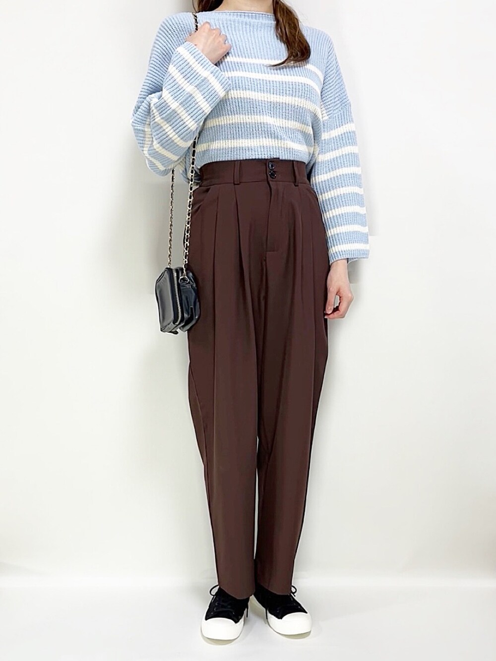 ブルー系のニット/セーター、ブラウン系のテーラードジャケット、ブラック系のスニーカーを着用したレディースの春コーディネートの2枚目の写真