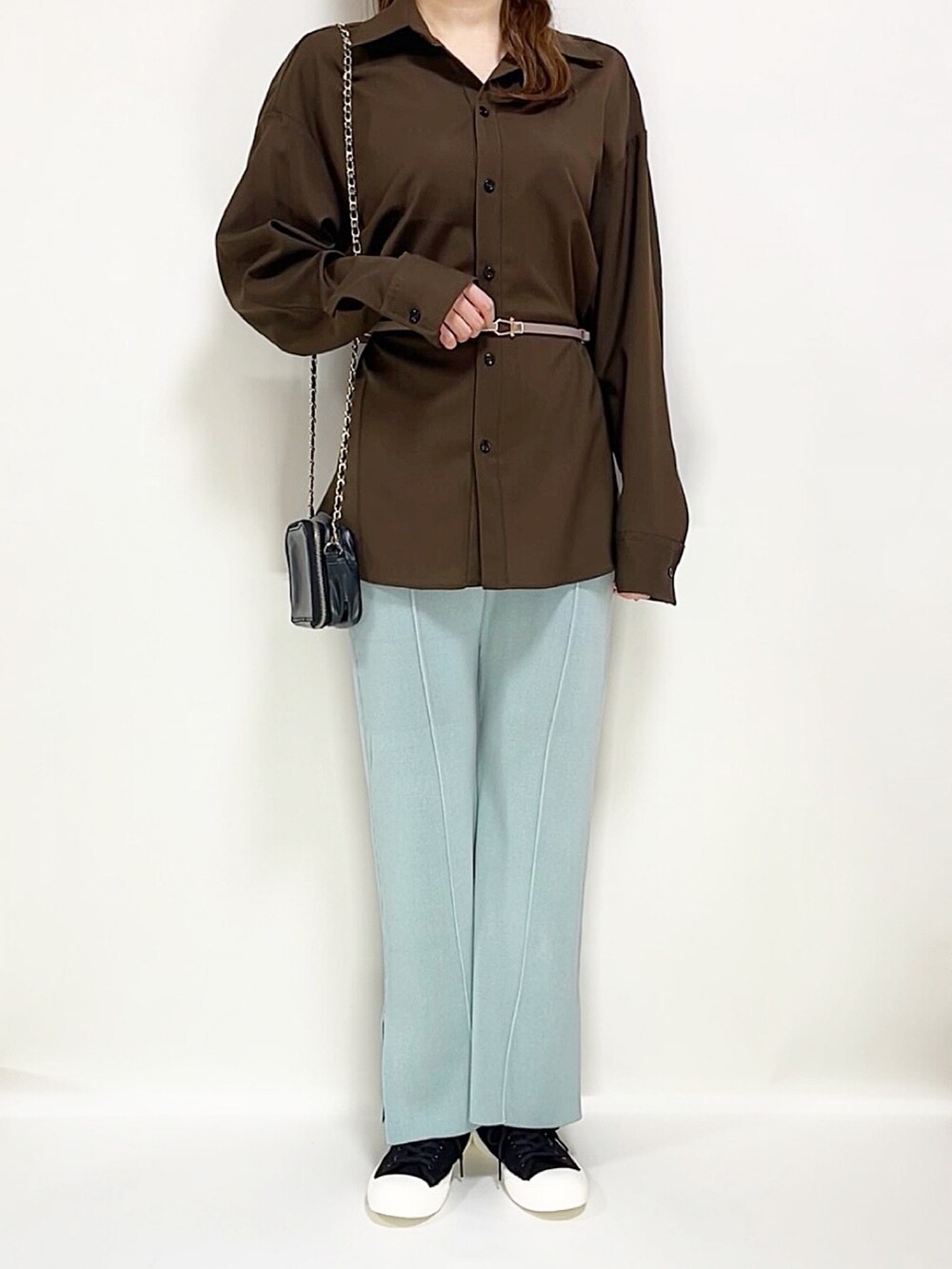 ブラウン系のシャツ/ブラウス、ブルー系のパンツ、ブラック系のスニーカーを着用したレディースの春コーディネートの2枚目の写真