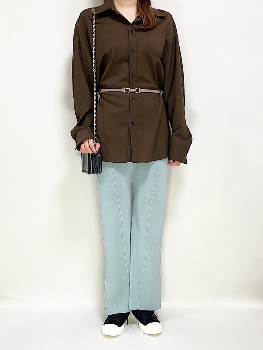 ブラウン系のシャツ/ブラウス、ブルー系のパンツ、ブラック系のスニーカーを着用したレディースの春コーディネートの3枚目の写真