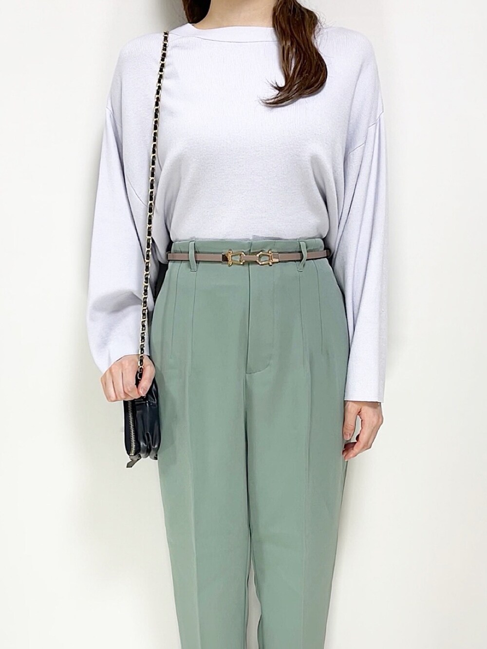 グリーン系のパンツ、ブルー系のニット/セーター、ブラック系のスニーカーを着用したレディースの春コーディネートの3枚目の写真