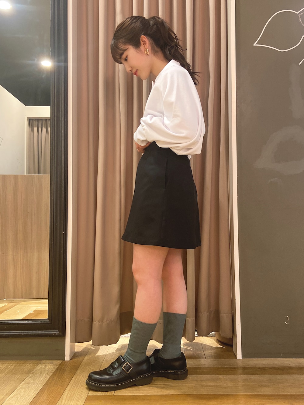 ホワイト系のTシャツ/カットソー、ブラック系のスカートを着用したレディースの春コーディネートの2枚目の写真