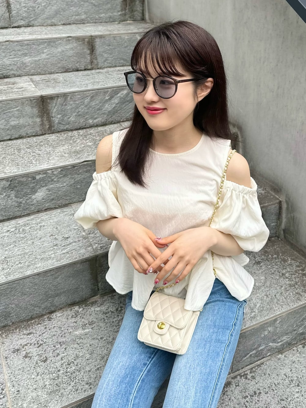 ホワイト系のシャツ/ブラウス、ブルー系のデニムパンツ、ブラック系のサンダルを着用したレディースの春コーディネートの3枚目の写真