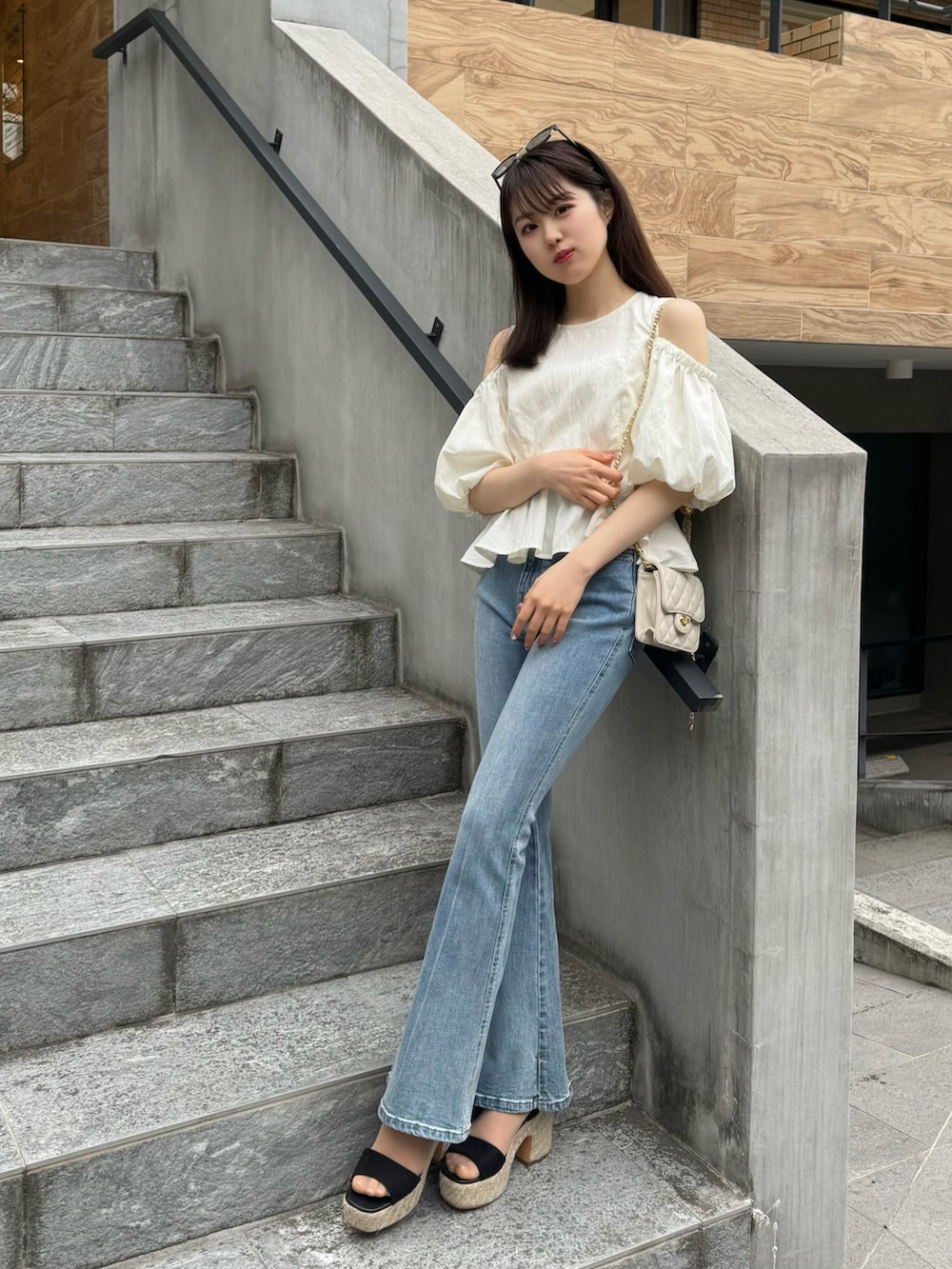 ホワイト系のシャツ/ブラウス、ブルー系のデニムパンツ、ブラック系のサンダルを着用したレディースの春コーディネートの2枚目の写真