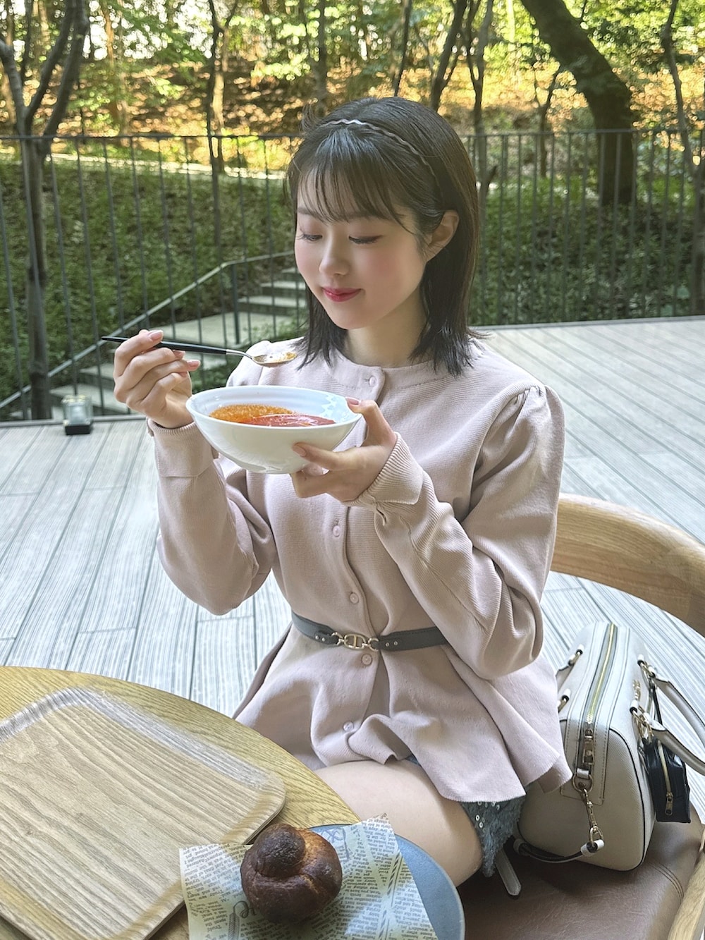 ベージュ系のカーディガン/ボレロ、ブルー系のデニムパンツ、ホワイト系のブーツを着用したレディースの春コーディネートの4枚目の写真