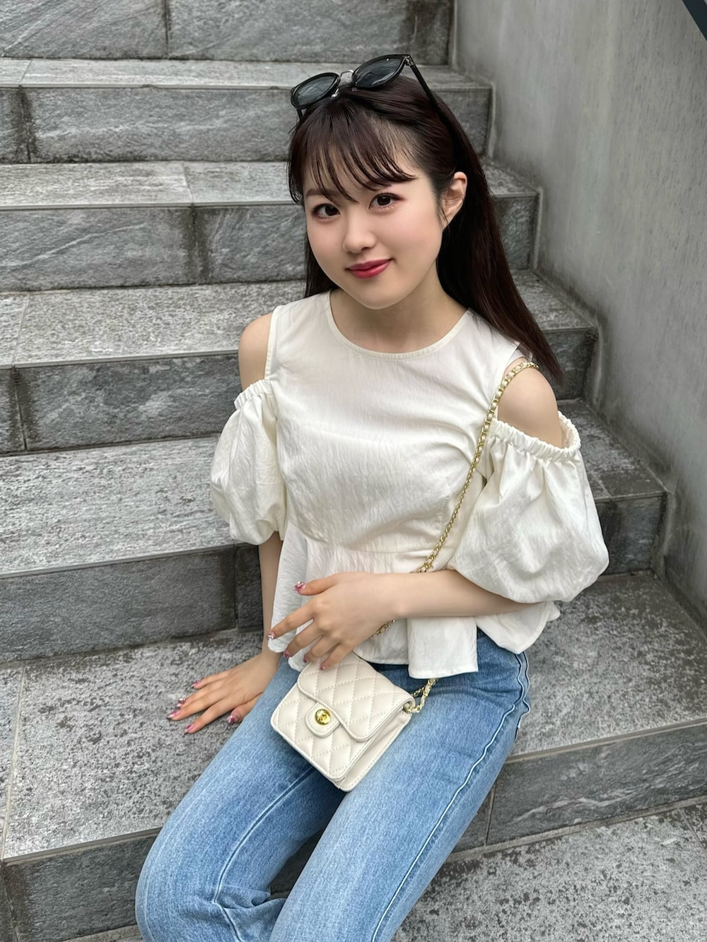 ホワイト系のシャツ/ブラウス、ブルー系のデニムパンツ、ブラック系のサンダルを着用したレディースの春コーディネートの4枚目の写真